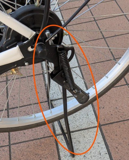 The rear wheel resting on the kickstand bar